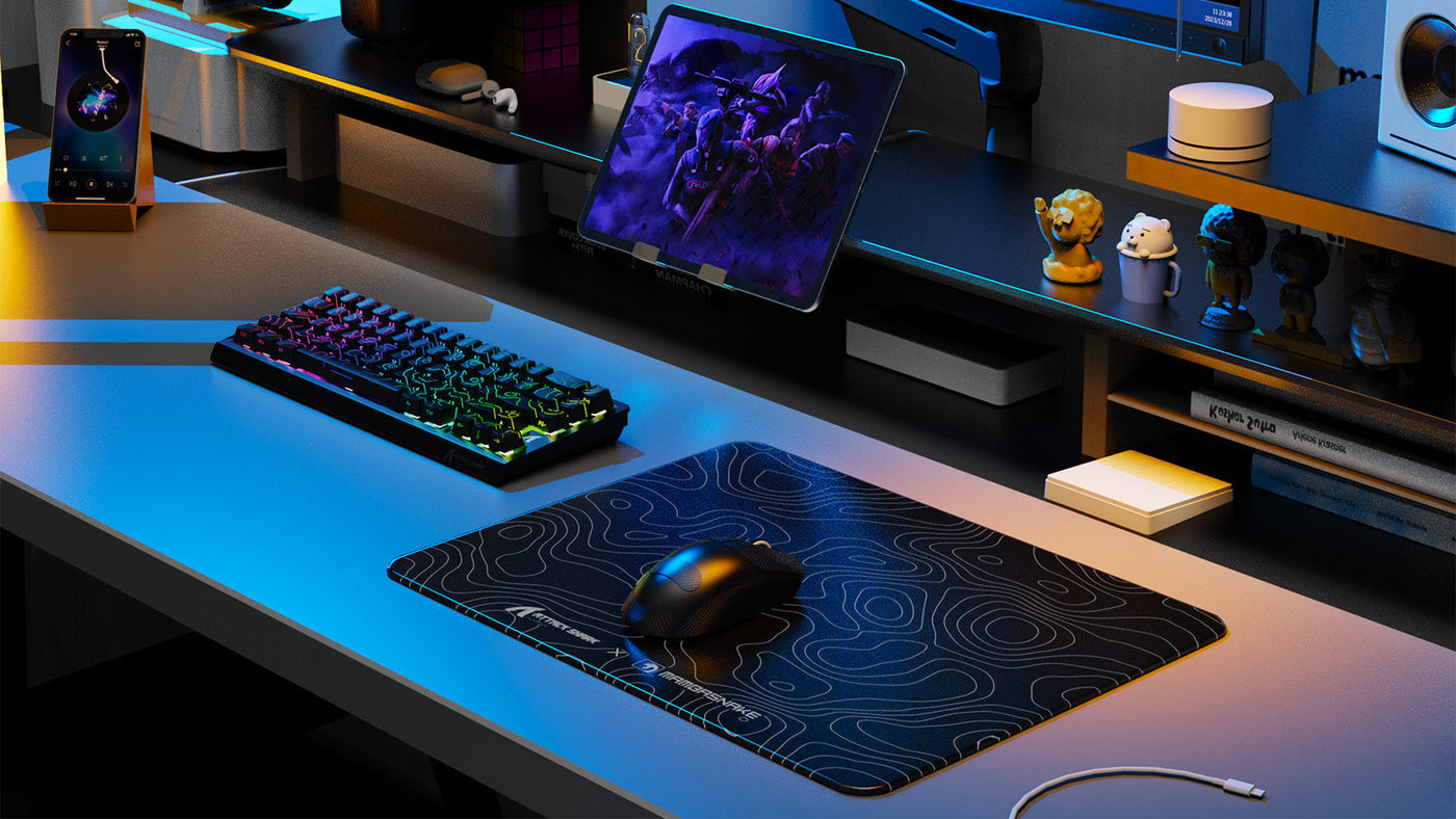 Gaming desk setup with mechanical keyboard, wireless mouse, RGB lighting, and desktop accessories