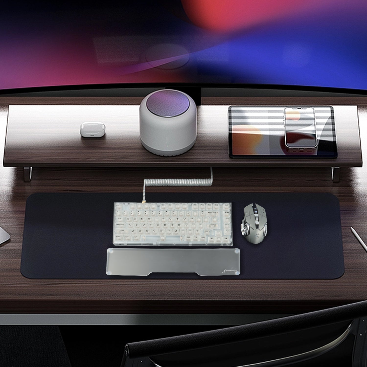 Modern gaming desk with red and white mechanical keyboard and clear acrylic wrist rest.